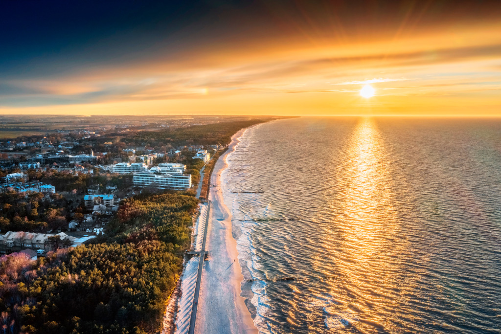 Rozległy widok na plażę w Mielnie w promieniach zachodzącego słońca
