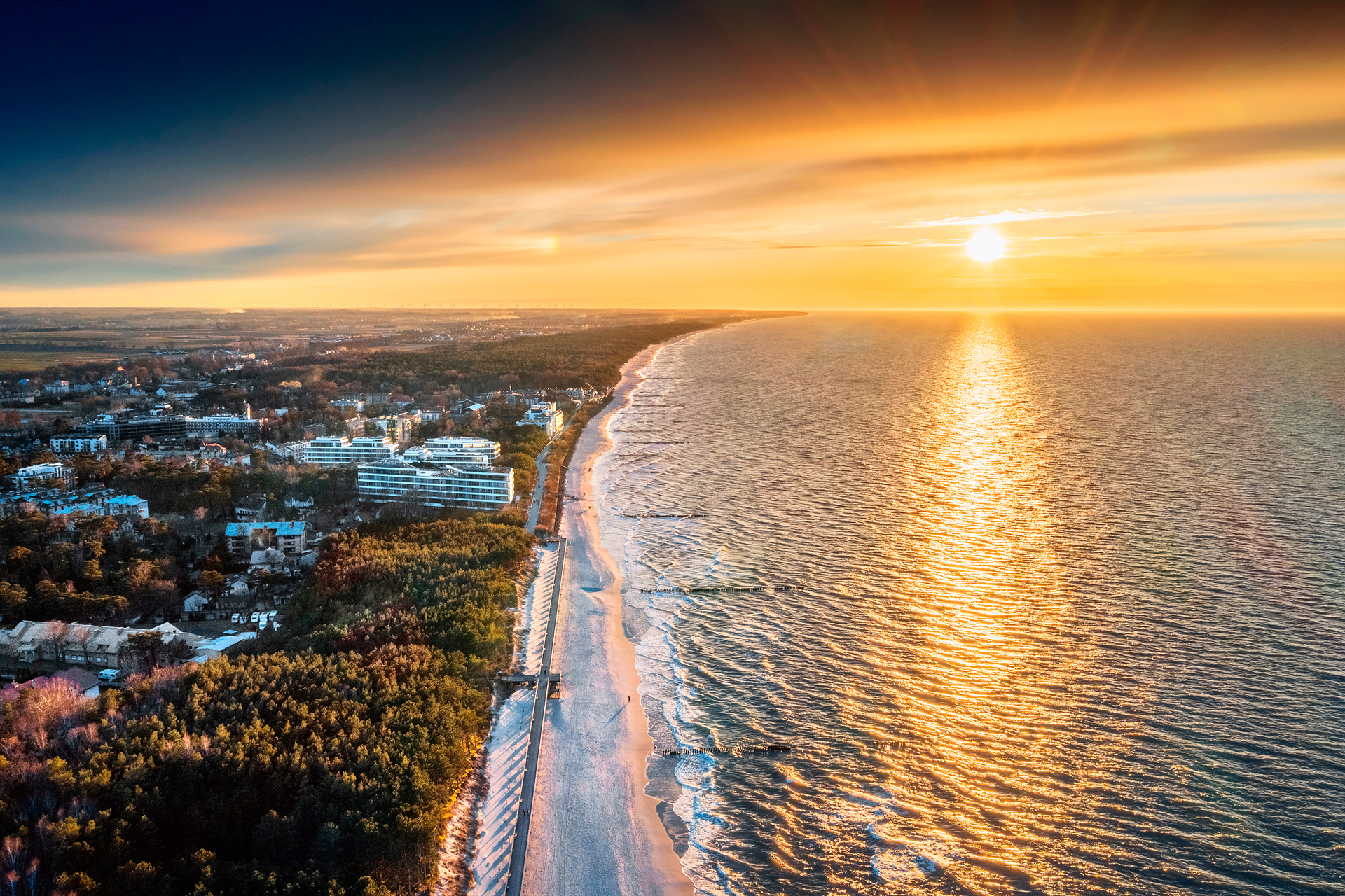 Rozległy widok na plażę w Mielnie w promieniach zachodzącego słońca